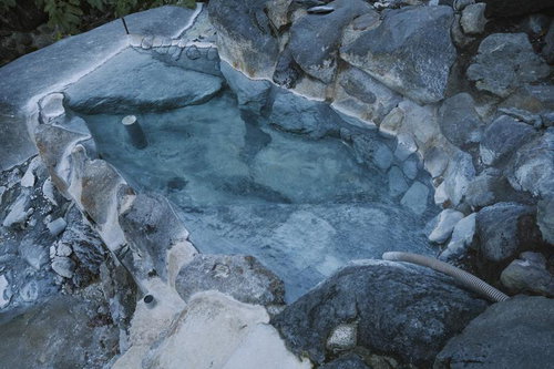 妙高山の山中で湯が満たされた岩で作られた野湯