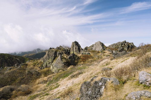 妙高山の山頂部に連なる日本岩と秋の草原・稜線風景