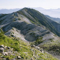白馬岳の稜線と山並みが連なる白砂の山頂風景の写真