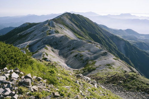 白馬岳の稜線と山並みが連なる白砂の山頂風景