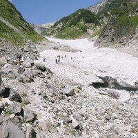 日本百名山・白馬岳の大雪渓で崩落した白馬尻を歩む登山者たちの写真