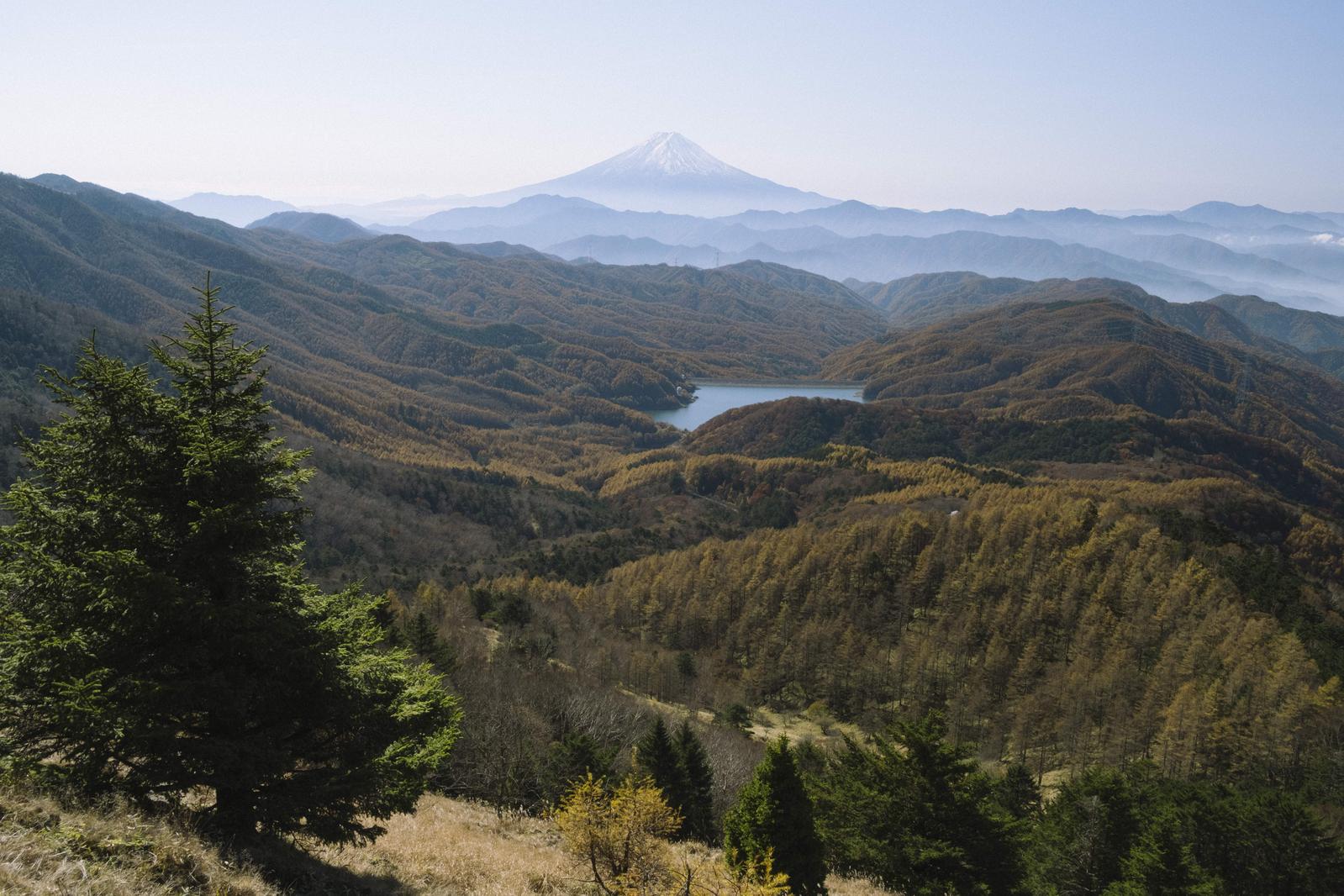 大菩薩嶺からの眺望。手前の樹林、秋色の山々、湖、遠景の富士山が層をなす