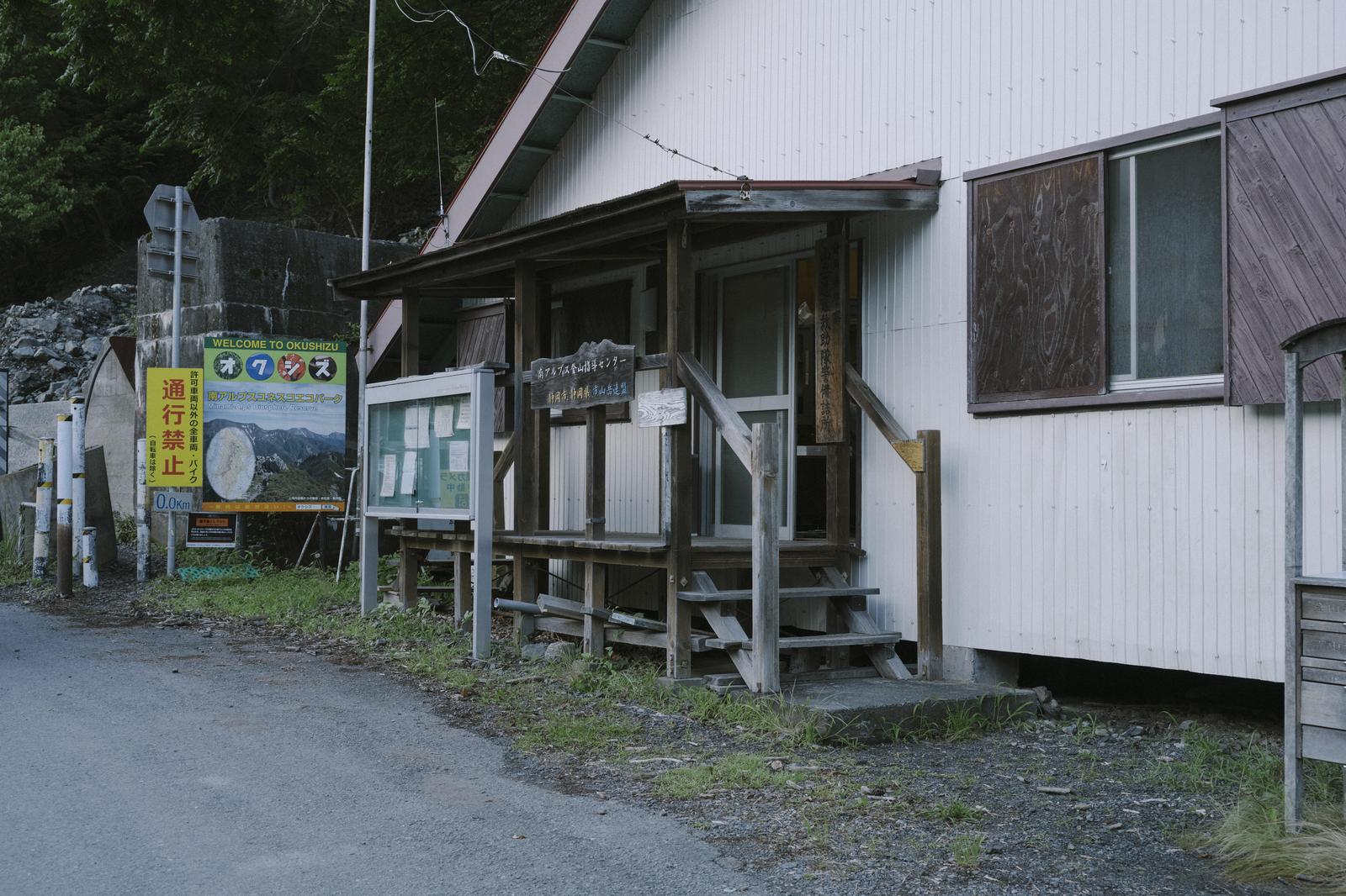 山間部に建つ沼平登山センターの外観と登山案内看板