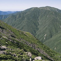 光岳の峰々から眺めた連なる山々と渓谷の雄大な山岳風景の写真
