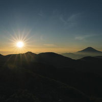 光岳からの朝日と富士山のシルエット、雲海と放射状の光線の写真