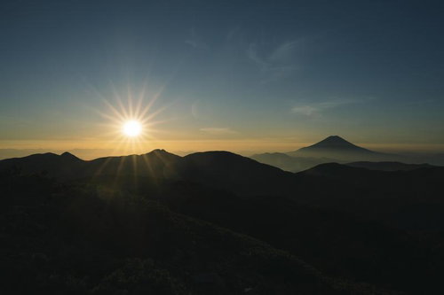 光岳からの朝日と富士山のシルエット、雲海と放射状の光線
