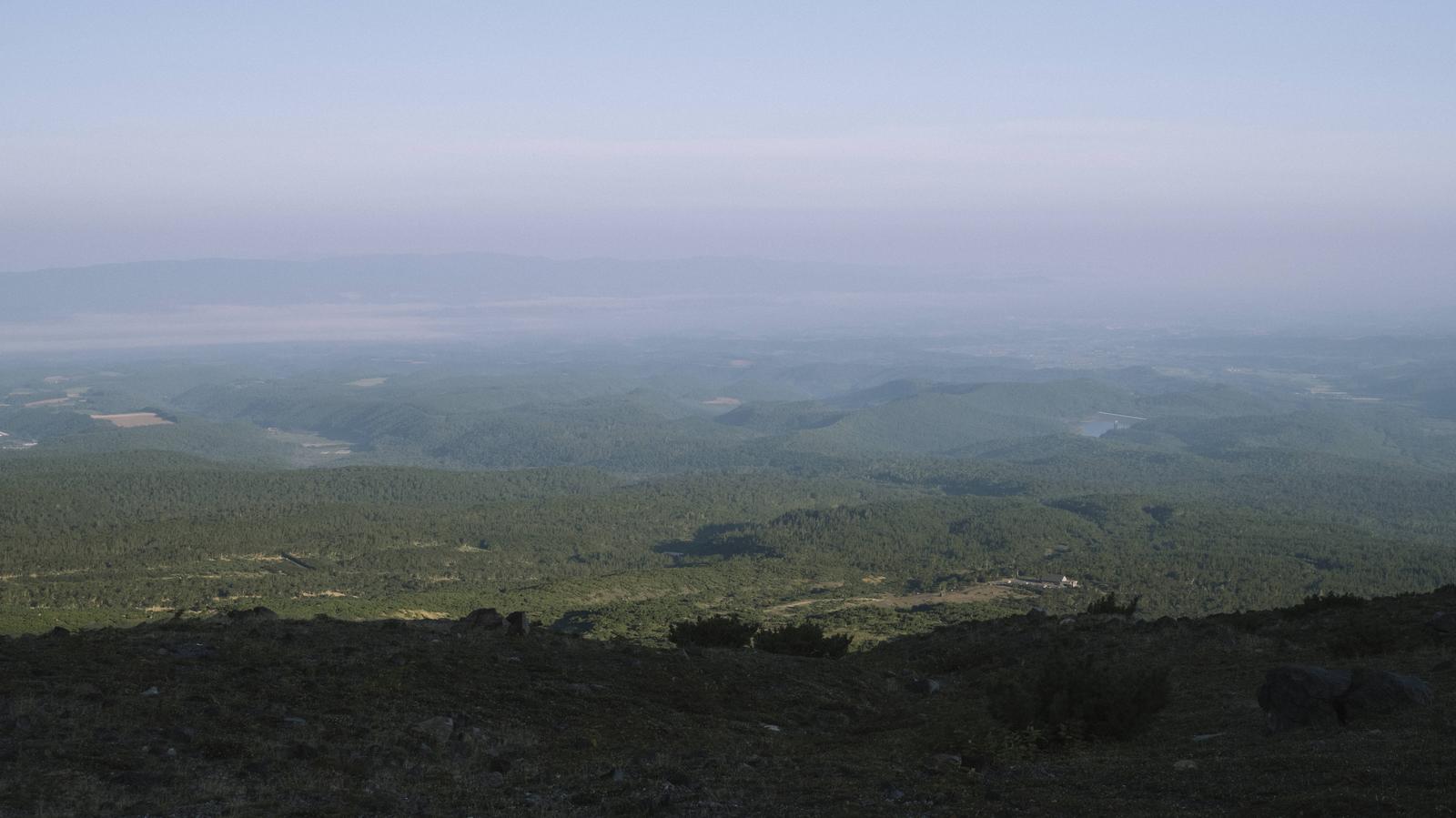 十勝岳の展望台から見た雲霧に包まれた森林と原野の風景