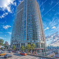 青空に映える高層マンションと駐車場の都市風景の写真