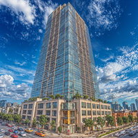 青空を背景に中央に佇む高級タワーマンションの写真