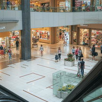 複数フロアで賑わう大型テナントビルの館内風景と来店客の歩行者風景のAI画像