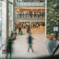 吹き抜けのショッピングモールを行き交う人々の写真