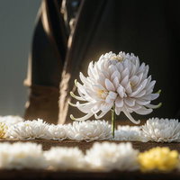 木製台に並ぶ白い菊の花と中央に立つ一輪の写真