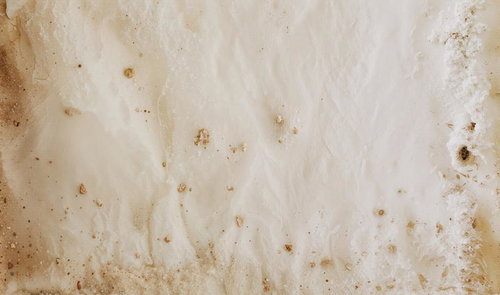 ホワイトベースに茶色い土汚れと粒状のシミが点在する古い紙テクスチャ