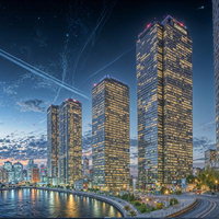 オレンジ色の夕焼けに映える都市の高層ビル群の写真