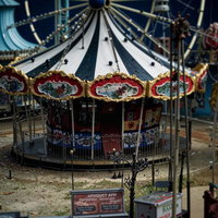 古びたメリーゴーラウンドと観覧車のある遊園地風景の写真