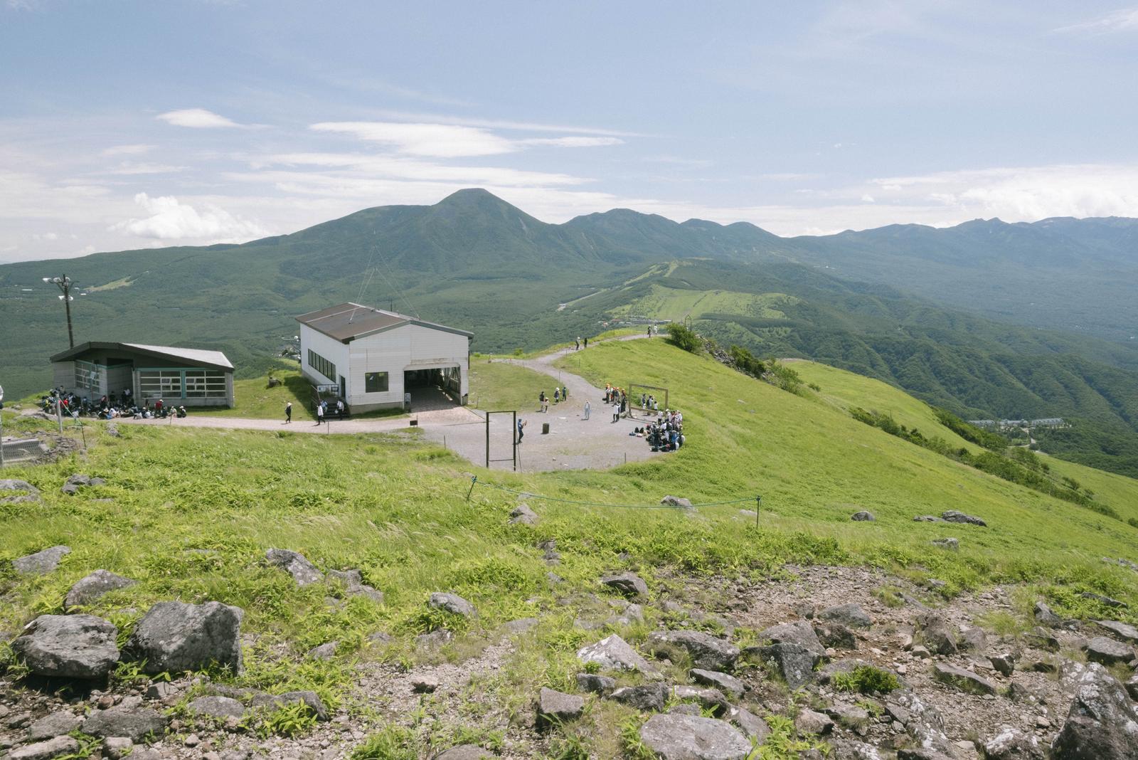 車山ロープウェイ山頂駅と背後の緑の高原、連なる山々