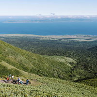 利尻山中腹から眺める礼文島と水平線、登山者の風景の写真