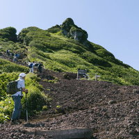 利尻岳山頂を見上げる登山者たち、火山斜面の登山道を進むの写真