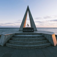 朝日を浴びる日本最北端の宗谷岬の記念碑と海景の写真