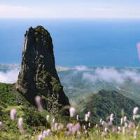 利尻岳の山頂に浮かぶローソク岩と水平線広がる景色の写真