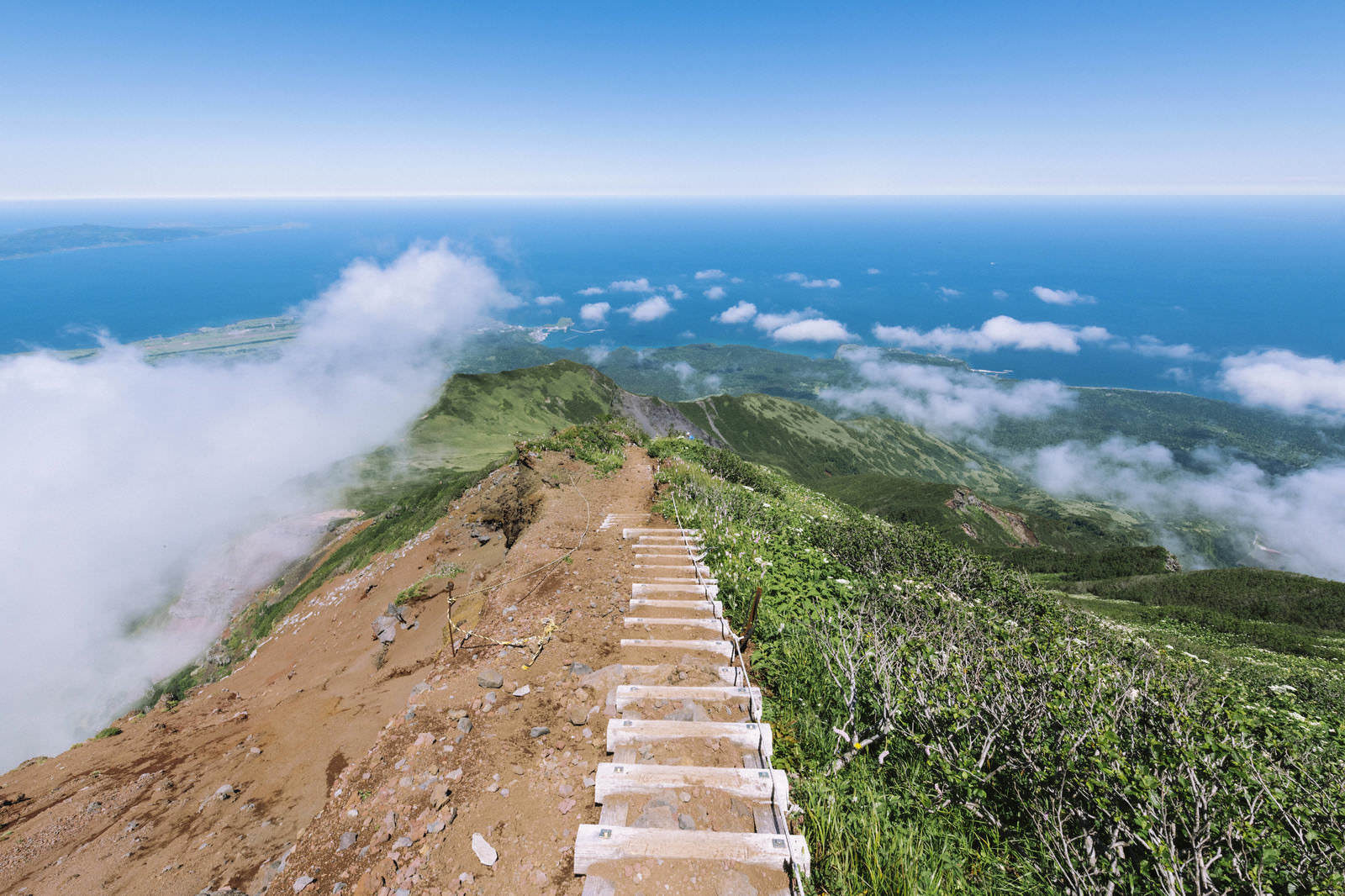 利尻岳の山頂付近で海と雲を見下ろす登山道の階段