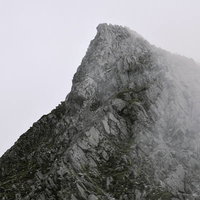 ガスから顔を出す奥穂高岳の切り立った岩肌の写真