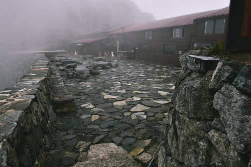 濃いガスに包まれた穂高岳山荘の石造り建築