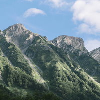 上高地から見上する奥穂高岳の雄大な岩山と青空の写真