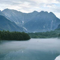 早朝の大正池に映る奥穂高岳と雲海の絶景の写真