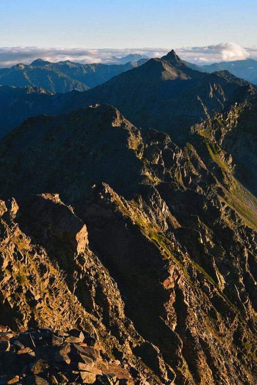 晴れ渡った朝日に照らされる奥穂高岳の稜線