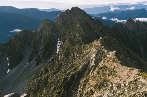 朝日に染まる北アルプスの前穂高岳と奥穂高岳の険しい峰々