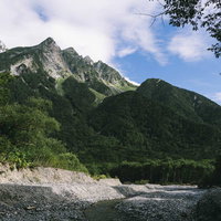 梓川の河原から見上げる奥穂高岳と明神岳の山々の写真