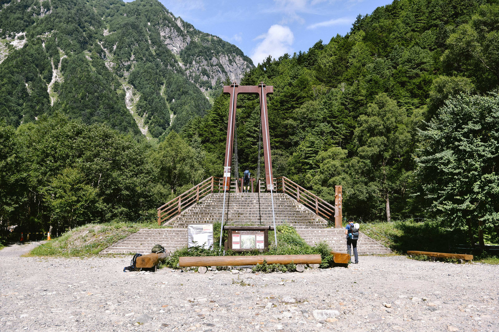 奥穂高岳の登山道に架かる赤い鋼鉄製の横尾大橋と山々