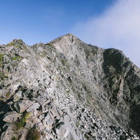 釣り尾根から見上げる奥穂高岳の岩峰と北アルプスの稜線の写真