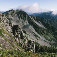 釣り尾根から見下ろす涸沢カールと連なる山並みの写真