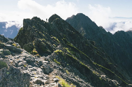 奥穂高岳の釣り尾根登山道で岩稜を進む登山者