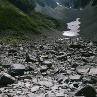 雪渓残る涸沢カール、岩場と渓流が織りなす奥穂高岳の山岳地形の写真
