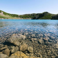 御嶽山の三ノ池、透明な湖面に映る山々と清流の写真