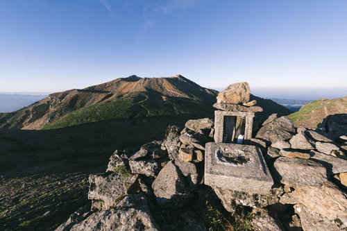 御嶽山の朝、山頂の石造りの祠と遠景の山々