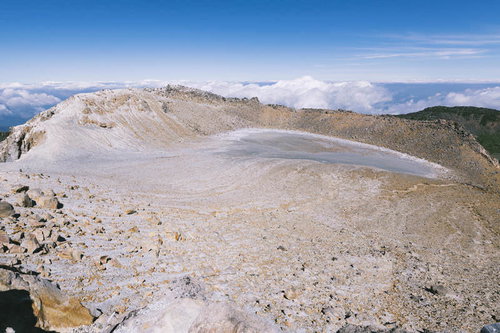 御嶽山の一ノ池、火口跡を望む山頂風景。火山灰に覆われた火口底