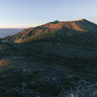 朝日に照らされる御嶽山の剣ヶ峰方面の雄大な山容の写真