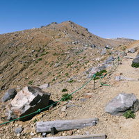 石室山荘側から見る御嶽山の剣ヶ峰と登山道の写真
