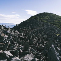 御嶽山の継子岳山頂に広がる積み石の景観と登山道の風景の写真