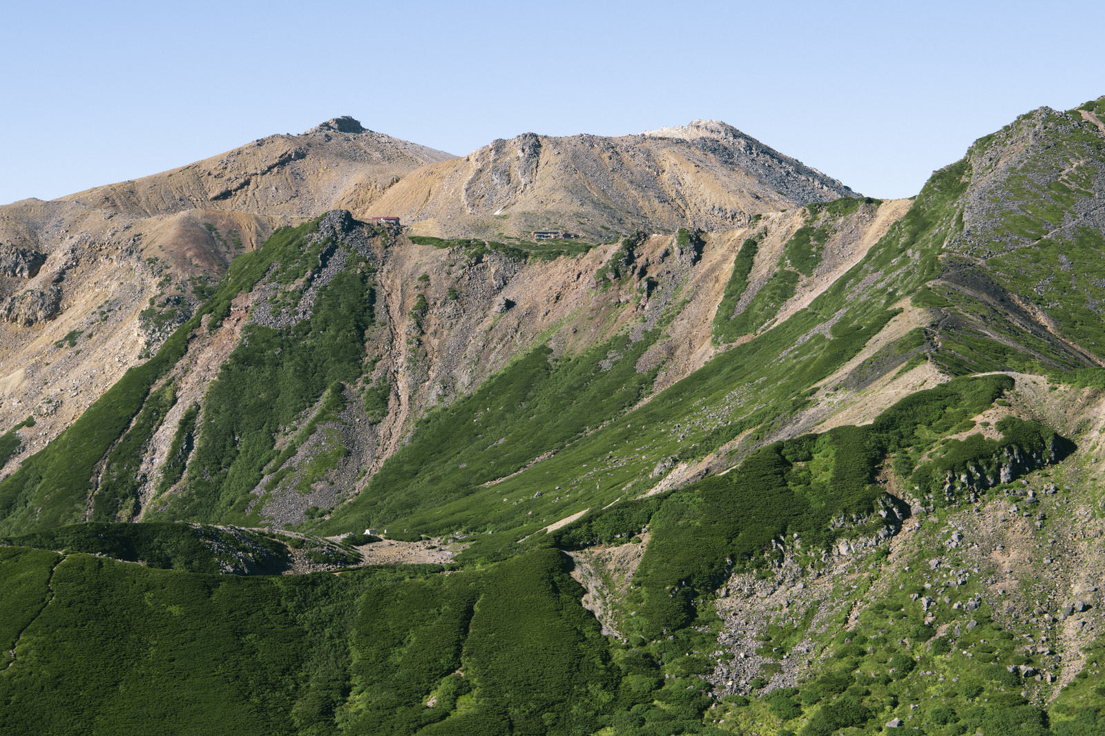 継子岳側から撮影した御嶽山の剣ヶ峰。緑の尾根と岩肌が印象的な山岳風景