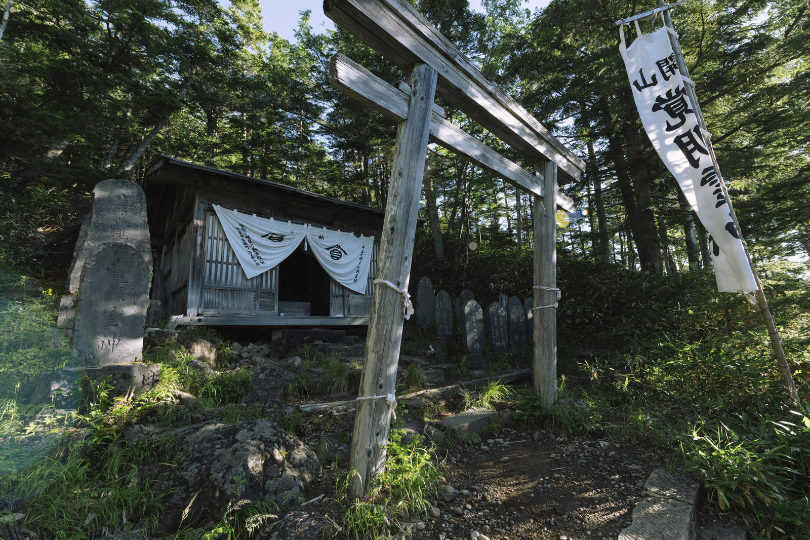 御嶽山の修行地にある木製の大きな鳥居と社殿、白いのれん