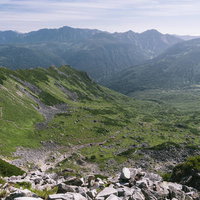 黒部五郎岳の巨大なカールと連なる山々の岩壁と雪渓の写真