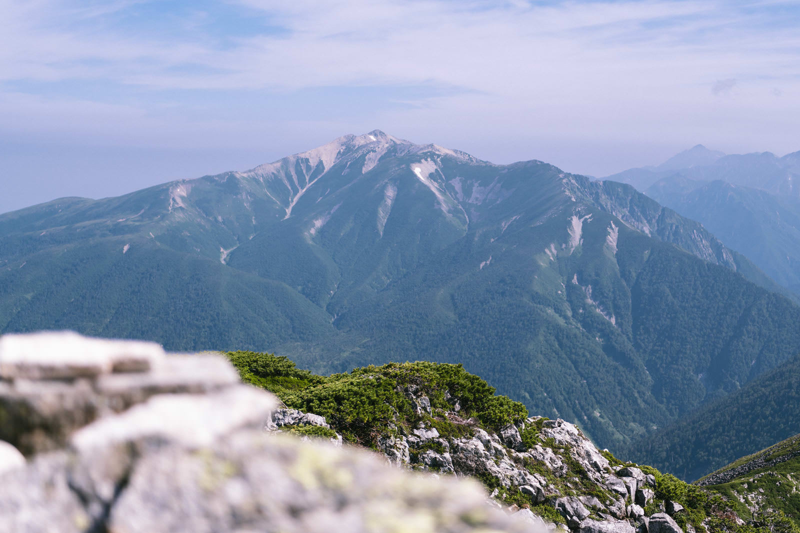 黒部五郎岳山頂から望む薬師岳と連なる山々と森林の風景