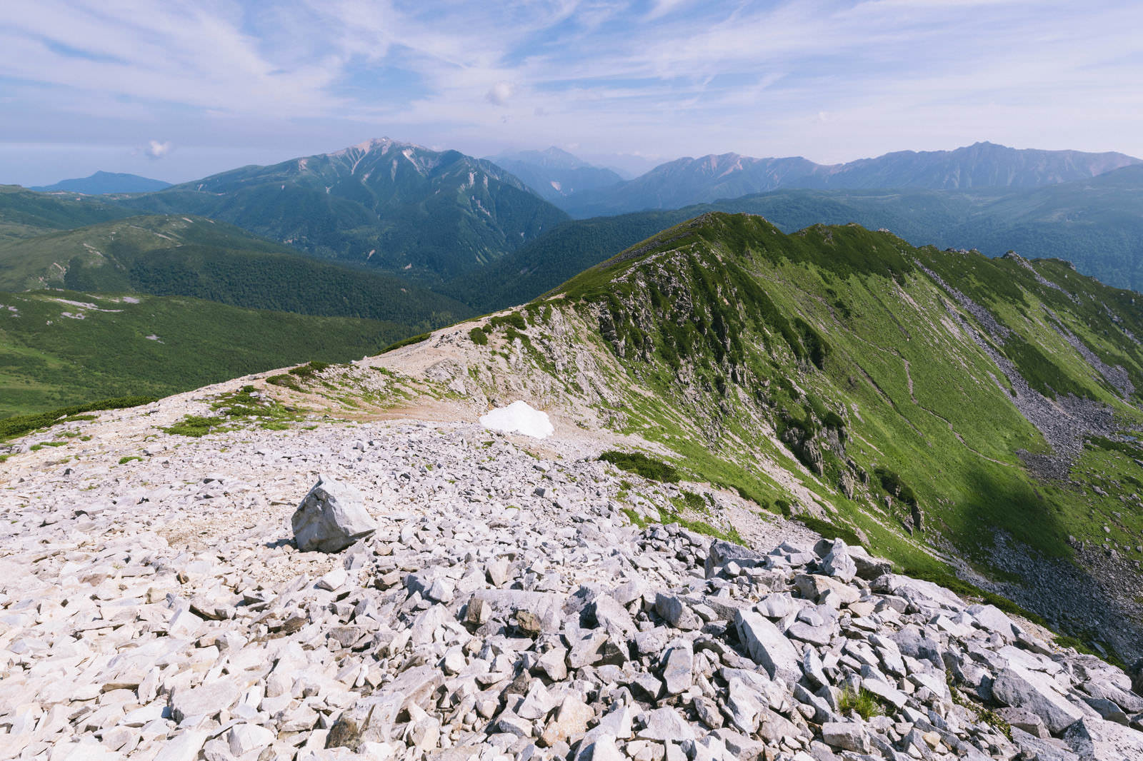 黒部五郎岳の山頂付近から見た岩礫の尾根と遠くの山々