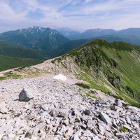 黒部五郎岳山頂付近の岩礫の尾根から見た山々の景色の写真