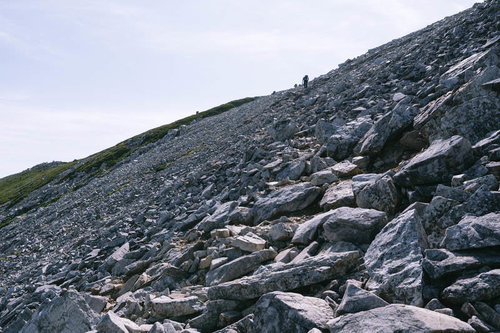 黒部五郎岳山頂直下の急勾配ガレ場を登る登山者